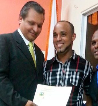 El diputado Mayobanex Martínez entrega un reconocimiento a Gelson Bladimir García Vargas durante un acto del Ayuntamiento de Navarrete, acompañado por John Zapata, encargado de la Juventud, el 31 de enero de 2015.