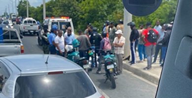 Accidente de tránsito en Santo Domingo Este con ambulancia, motocicletas y personas reunidas en el lugar.