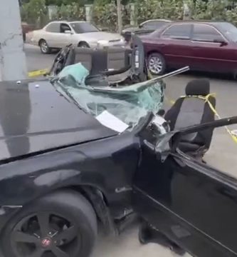 Honda Civic negro severamente afectado tras accidente en una avenida de Santiago.