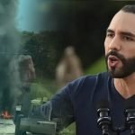 Nayib Bukele ofrece declaraciones mientras se observa humo y vehículos militares en una escena de tensión.