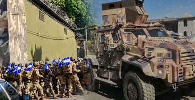 Soldados salvadoreños con banderas de El Salvador junto a un vehículo blindado durante su despliegue en Haití.