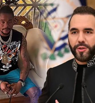 La Mossanú sentado en un sillón junto a una imagen del presidente Nayib Bukele durante una comparecencia pública.
